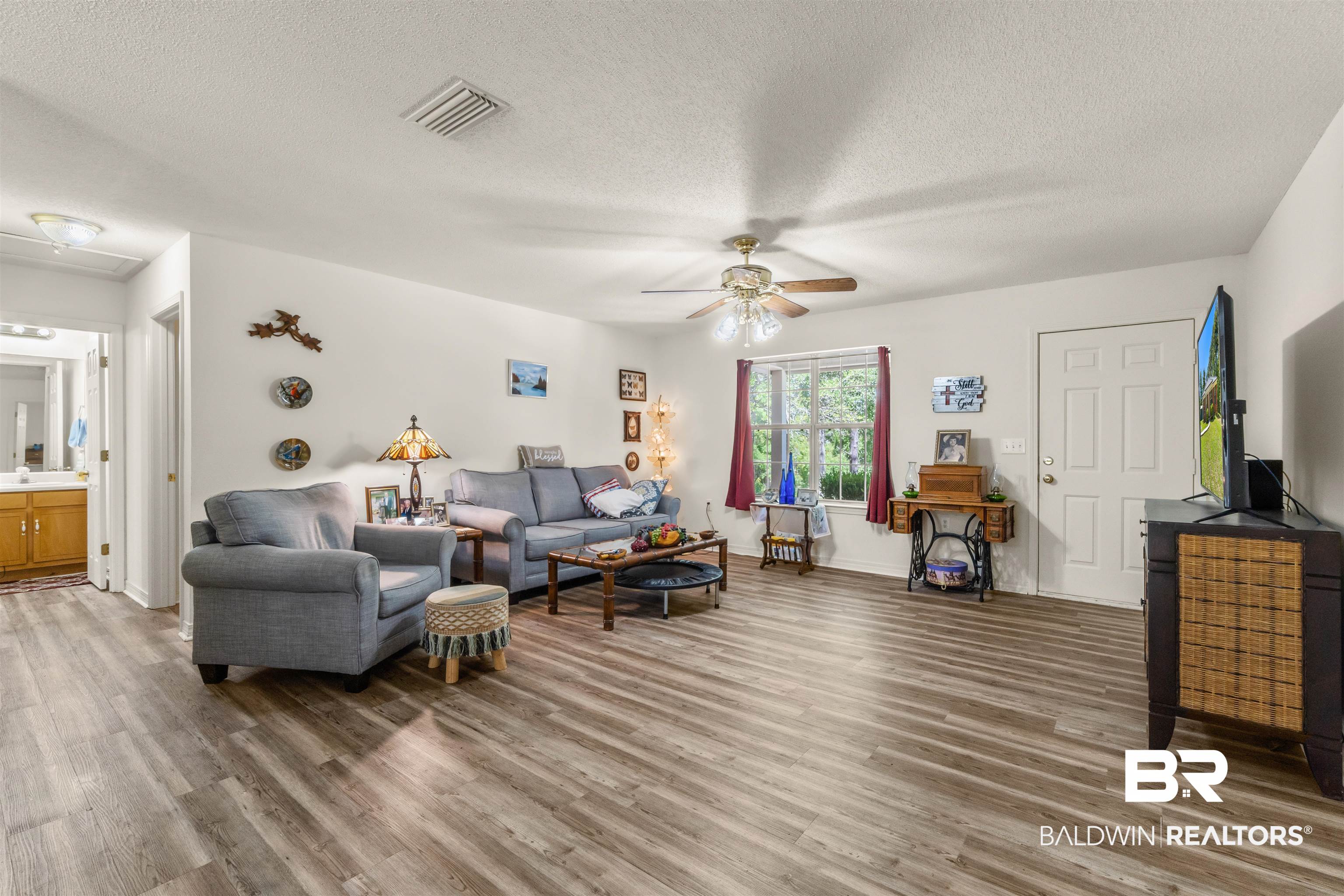35893 Pine Road South Stapleton, AL 36578 - Photo 7 of 31 Open-concept living space featuring wood-finish flooring, a ceiling fan with integrated lighting, and a window with natural light