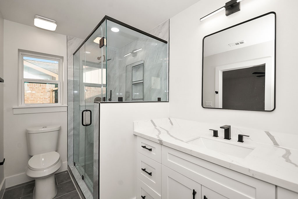 6106 Rutherglenn Drive Houston, TX 77096 - Photo 24 of 41 Beautifully updated bathroom featuring modern vanity, sleek fixtures, and glass-enclosed shower.
