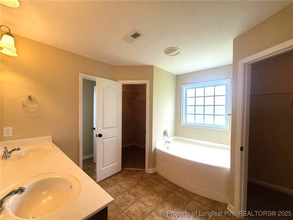 265 Carolina Oaks Circle Linden, NC 28356 - Photo 19 of 31 a bathroom with a tub sink and mirror
