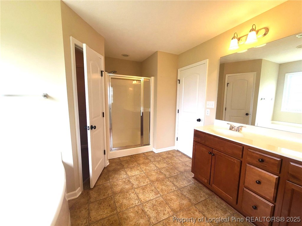265 Carolina Oaks Circle Linden, NC 28356 - Photo 21 of 31 a spacious bathroom with a double vanity sink a mirror and a shower