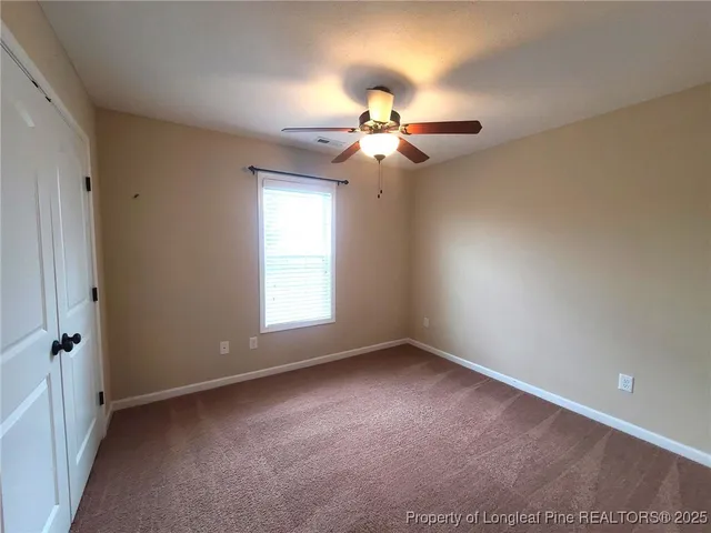 a view of a room with a ceiling fan and a window