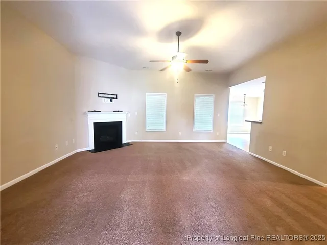 a view of empty room with a fireplace and windows