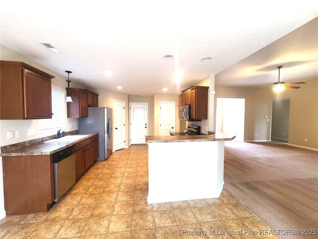265 Carolina Oaks Circle Linden, NC 28356 - Photo 10 of 31 a large kitchen with kitchen island a sink a stove a refrigerator and a dining table with wooden floor
