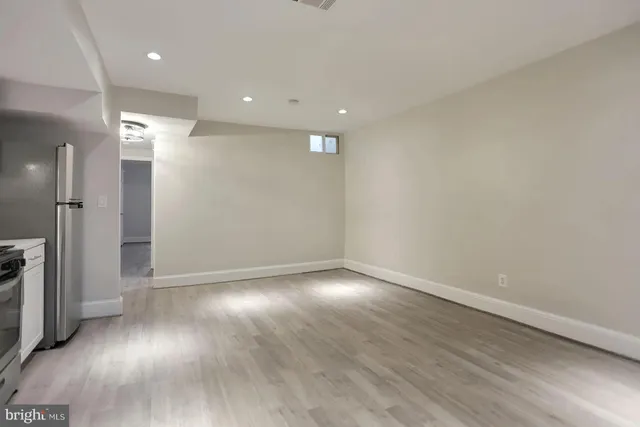an empty room with wooden floor and a window