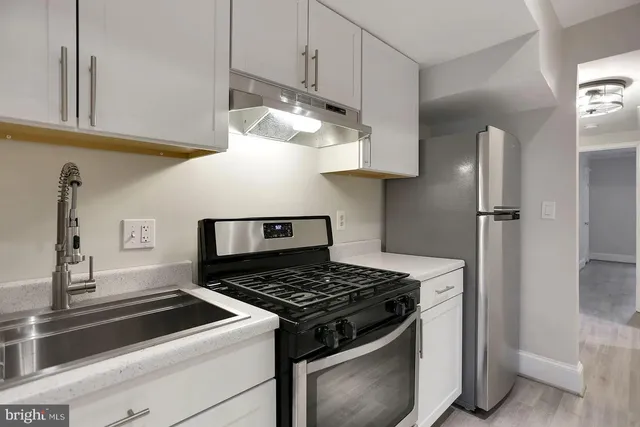 a stove top oven sitting inside of a kitchen