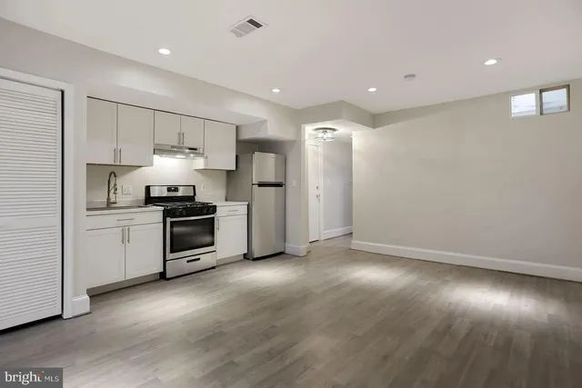a kitchen with stainless steel appliances a refrigerator and a stove top oven