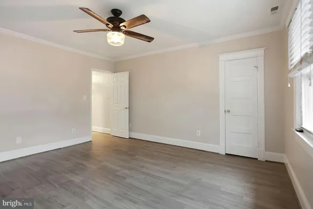 an empty room with fan and windows