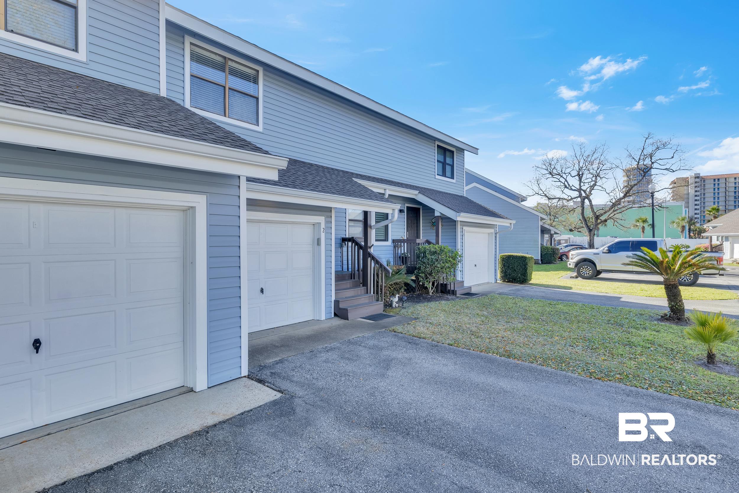 3256 Loop Road, Unit 2 Orange Beach, AL 36561 - Photo 2 of 25 Light blue siding exterior featuring white trim and multiple windows