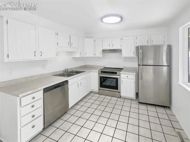a kitchen with white cabinets and white appliances