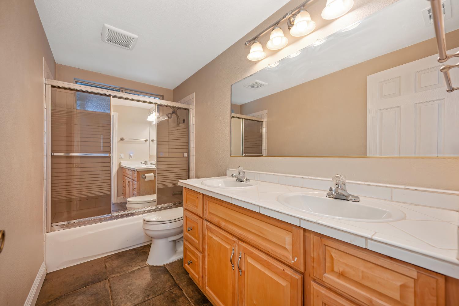2700 Lassen Way Rocklin, CA 95677 - Photo 14 of 36 a bathroom with a granite countertop sink a toilet a mirror and shower
