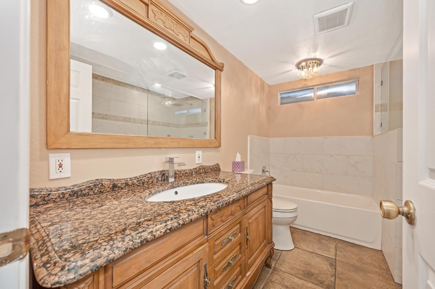 2700 Lassen Way Rocklin, CA 95677 - Photo 20 of 36 a bathroom with a granite countertop sink a mirror and a bathtub
