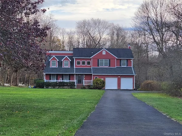 a view of a brick house next to a yard with big trees