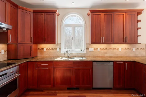 a kitchen with granite countertop wooden cabinets a sink and dishwasher