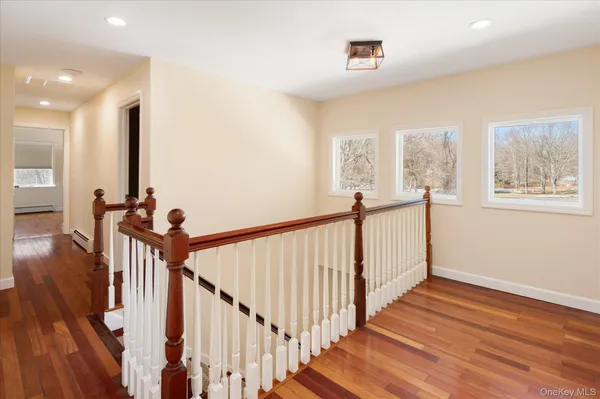 a view of hallway with stairs and wooden floor