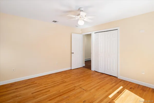 a view of a room with wooden floor and a ceiling fan