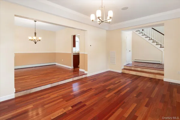 a view of empty room with wooden floor and window