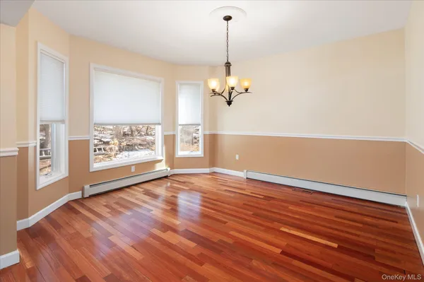 a view of empty room with wooden floor and window