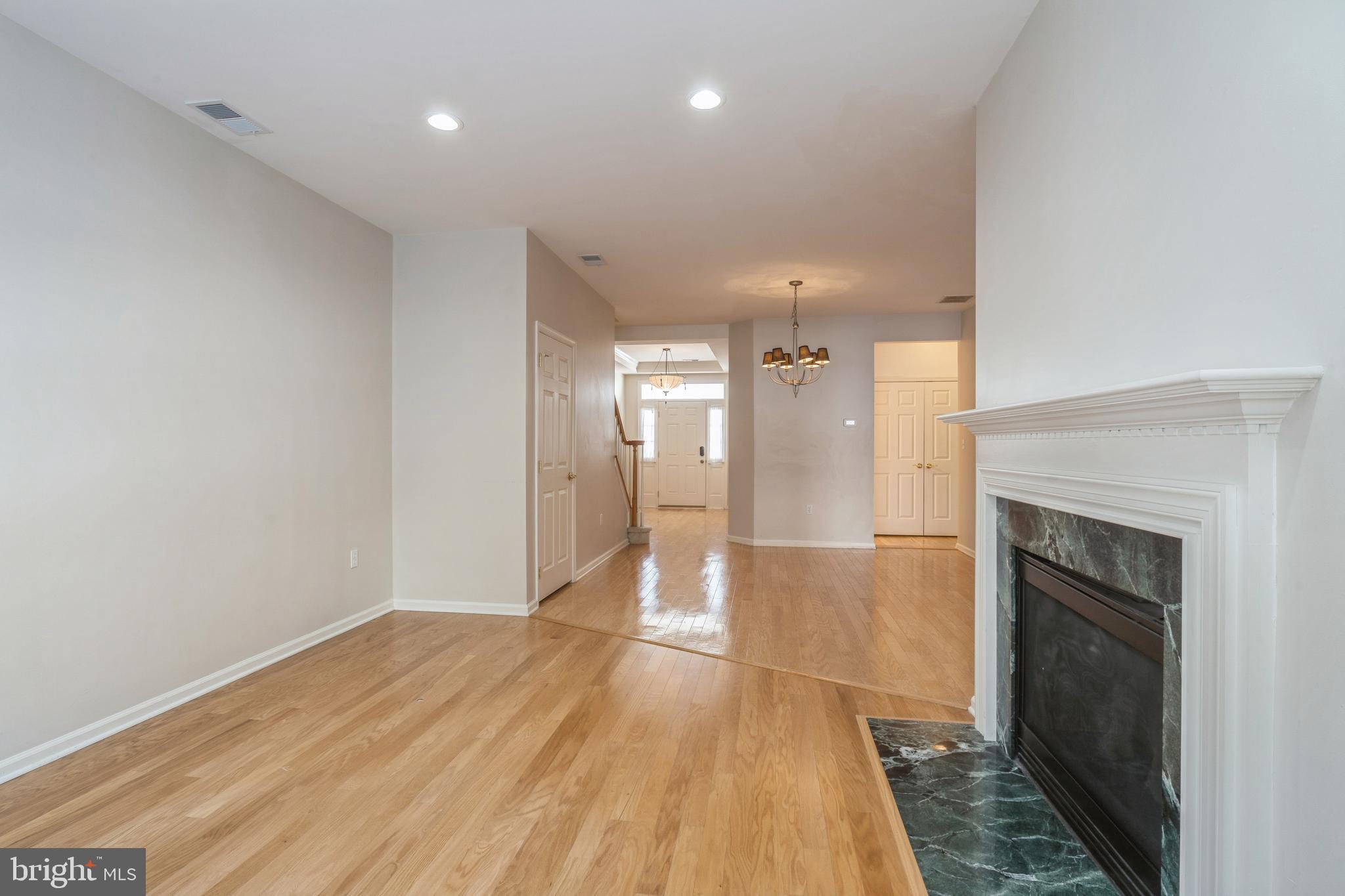 250 Brinley Drive Pennington, NJ 08534 - Photo 7 of 34 a view of a hallway with wooden floor and a fireplace