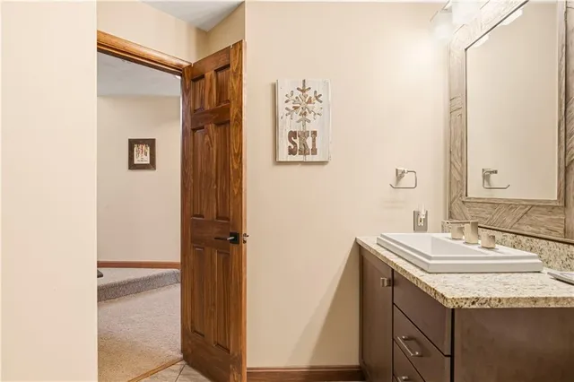 a bathroom with a granite countertop sink a mirror and a shower