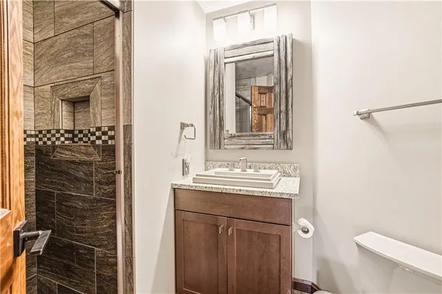 a bathroom with a sink a toilet and shower