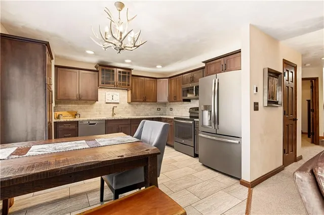 a kitchen with kitchen island a refrigerator a stove a sink and cabinets