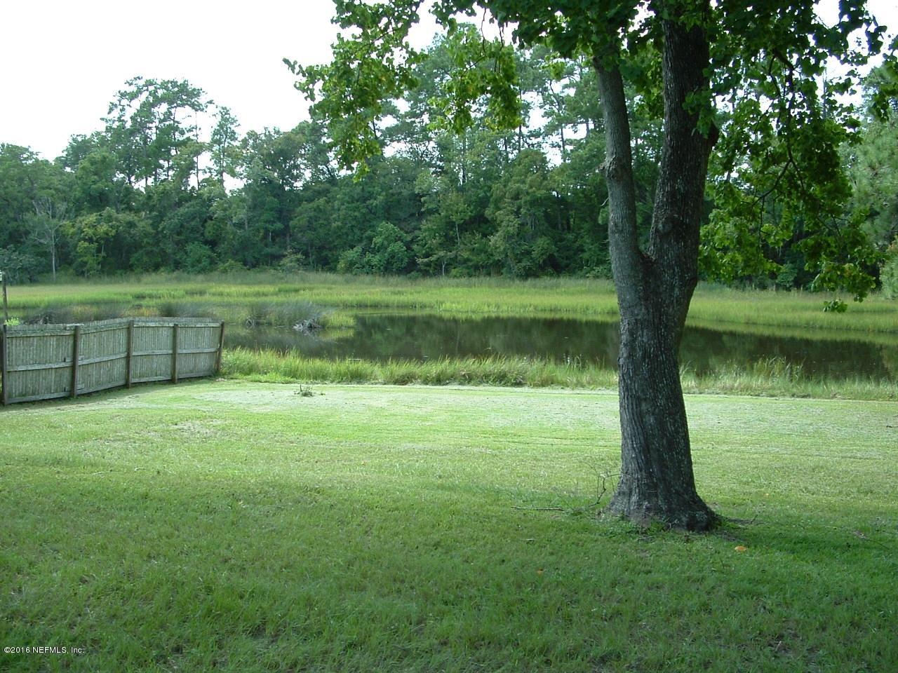 10460 Tulsa Road Jacksonville, FL 32218 - Photo 3 of 31 a view of a green field with a tree