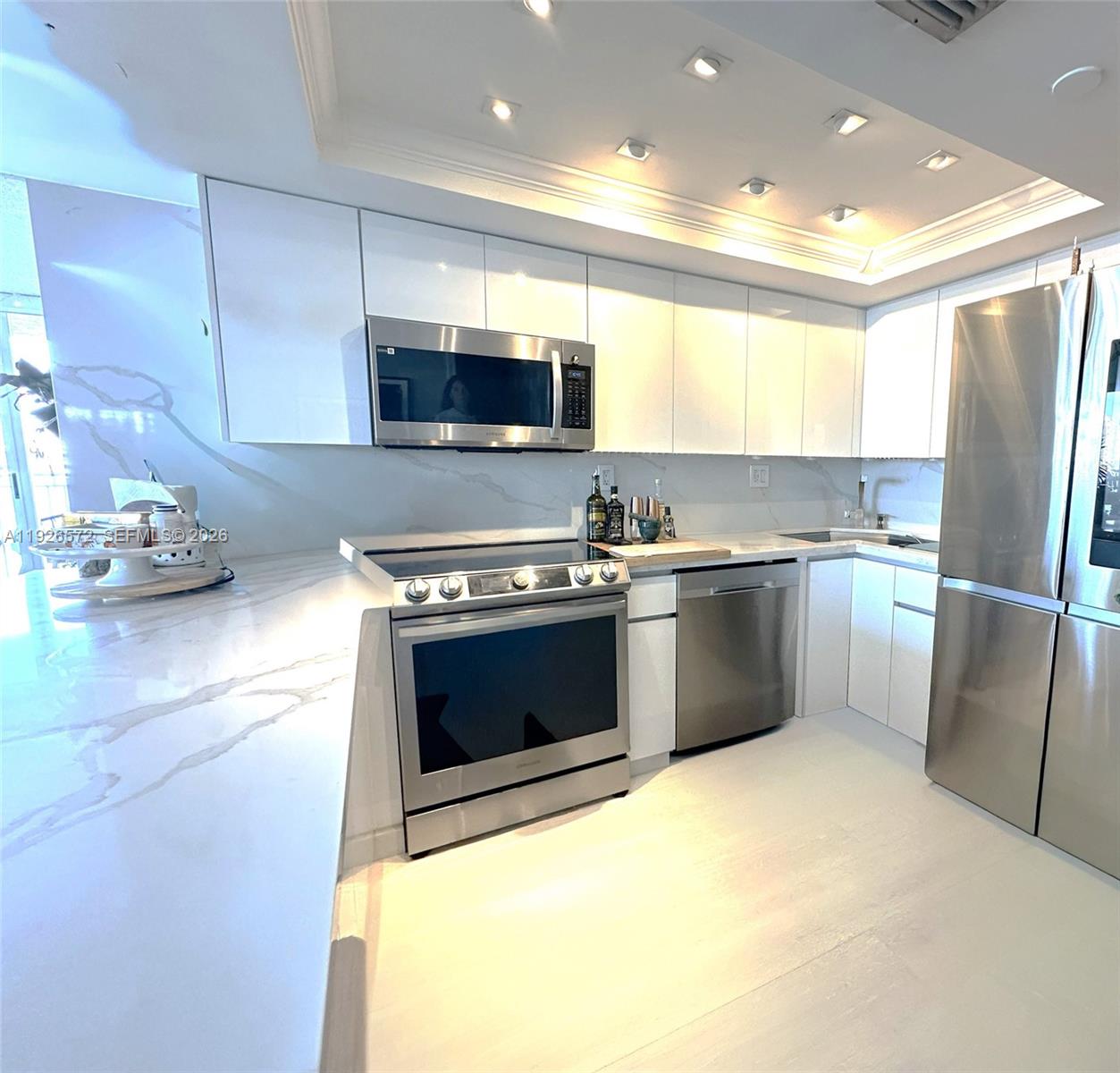 18000 North Bay Road, Unit 603 Sunny Isles Beach, FL 33160 - Photo 15 of 30 a kitchen with stainless steel appliances a refrigerator a sink a stove top oven a counter space and cabinets