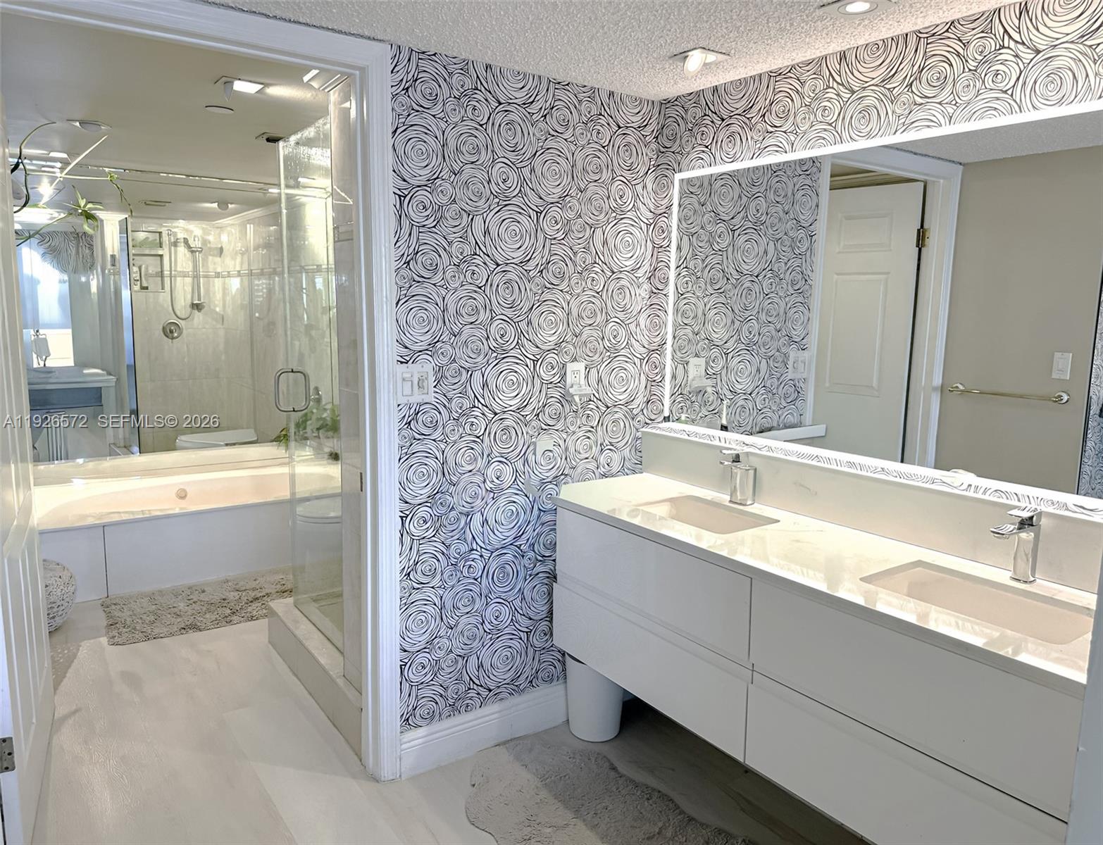 18000 North Bay Road, Unit 603 Sunny Isles Beach, FL 33160 - Photo 19 of 30 a bathroom with a granite countertop sink mirror and a bath tub