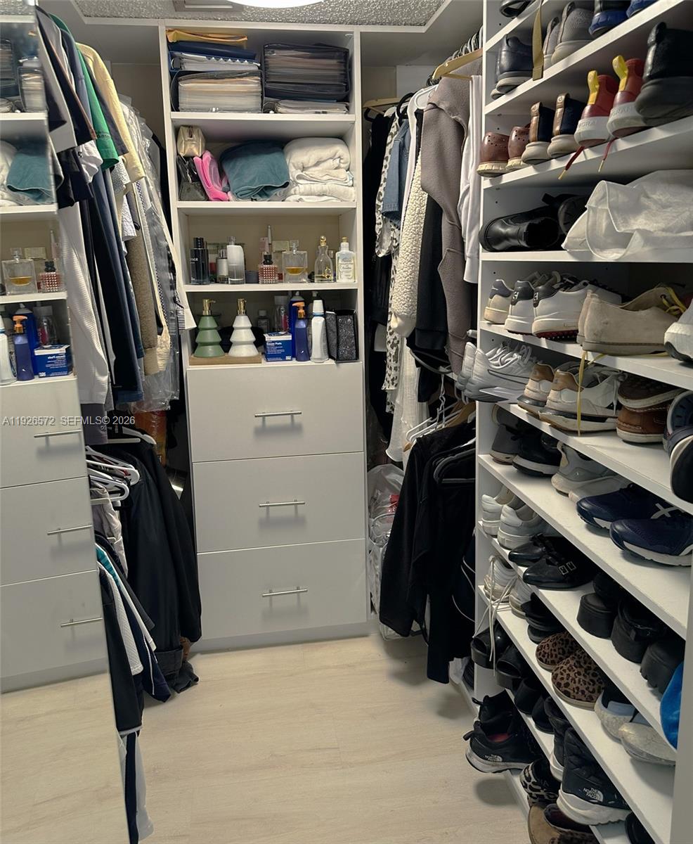 18000 North Bay Road, Unit 603 Sunny Isles Beach, FL 33160 - Photo 20 of 30 a view of walk in closet with clothes and shoes
