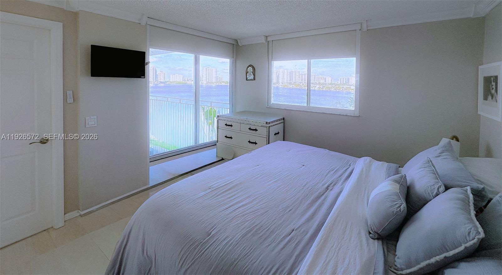18000 North Bay Road, Unit 603 Sunny Isles Beach, FL 33160 - Photo 22 of 30 a bedroom with a bed and a flat screen tv