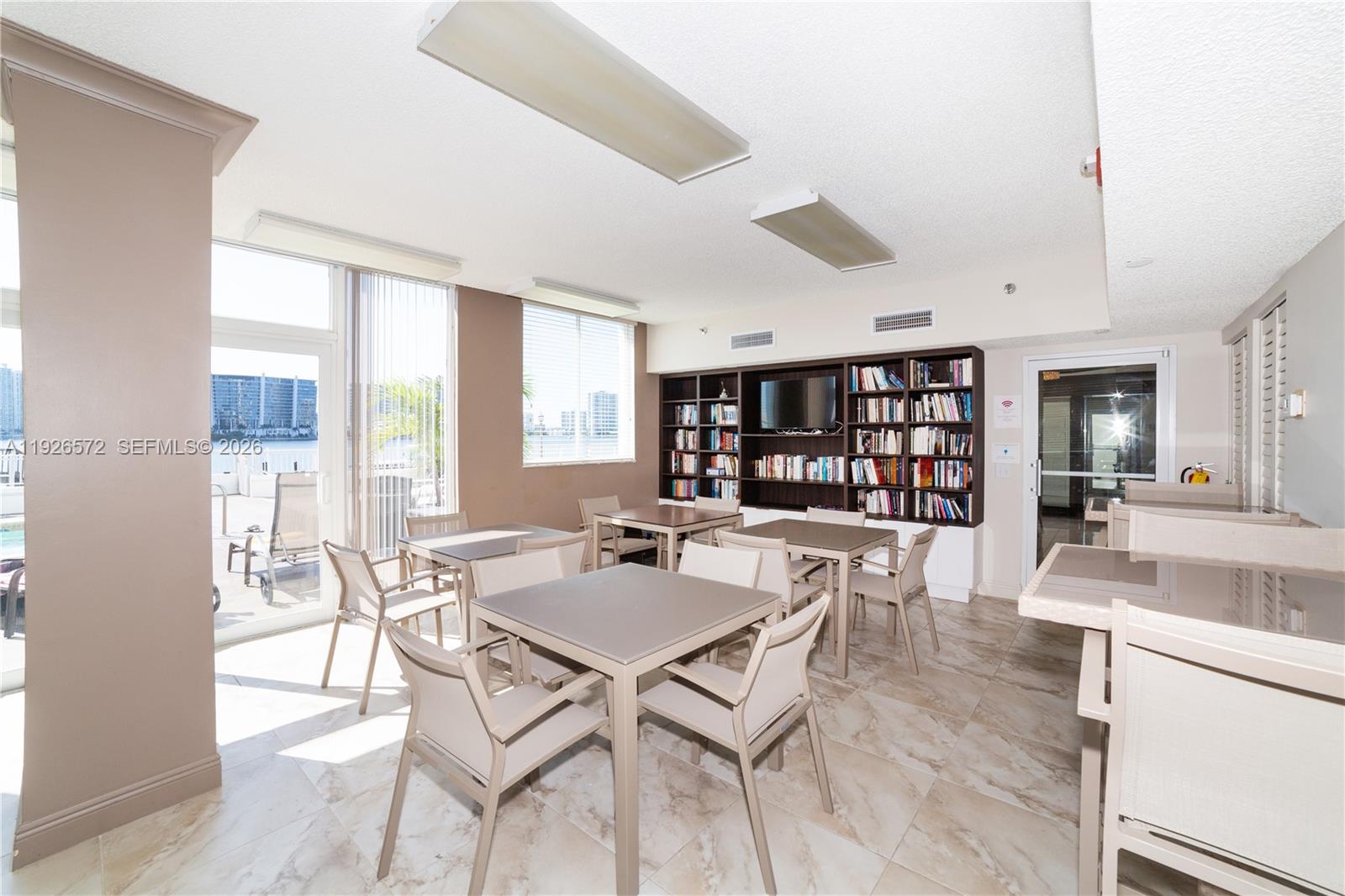 18000 North Bay Road, Unit 603 Sunny Isles Beach, FL 33160 - Photo 26 of 30 a view of a dining room with furniture and a book shelf