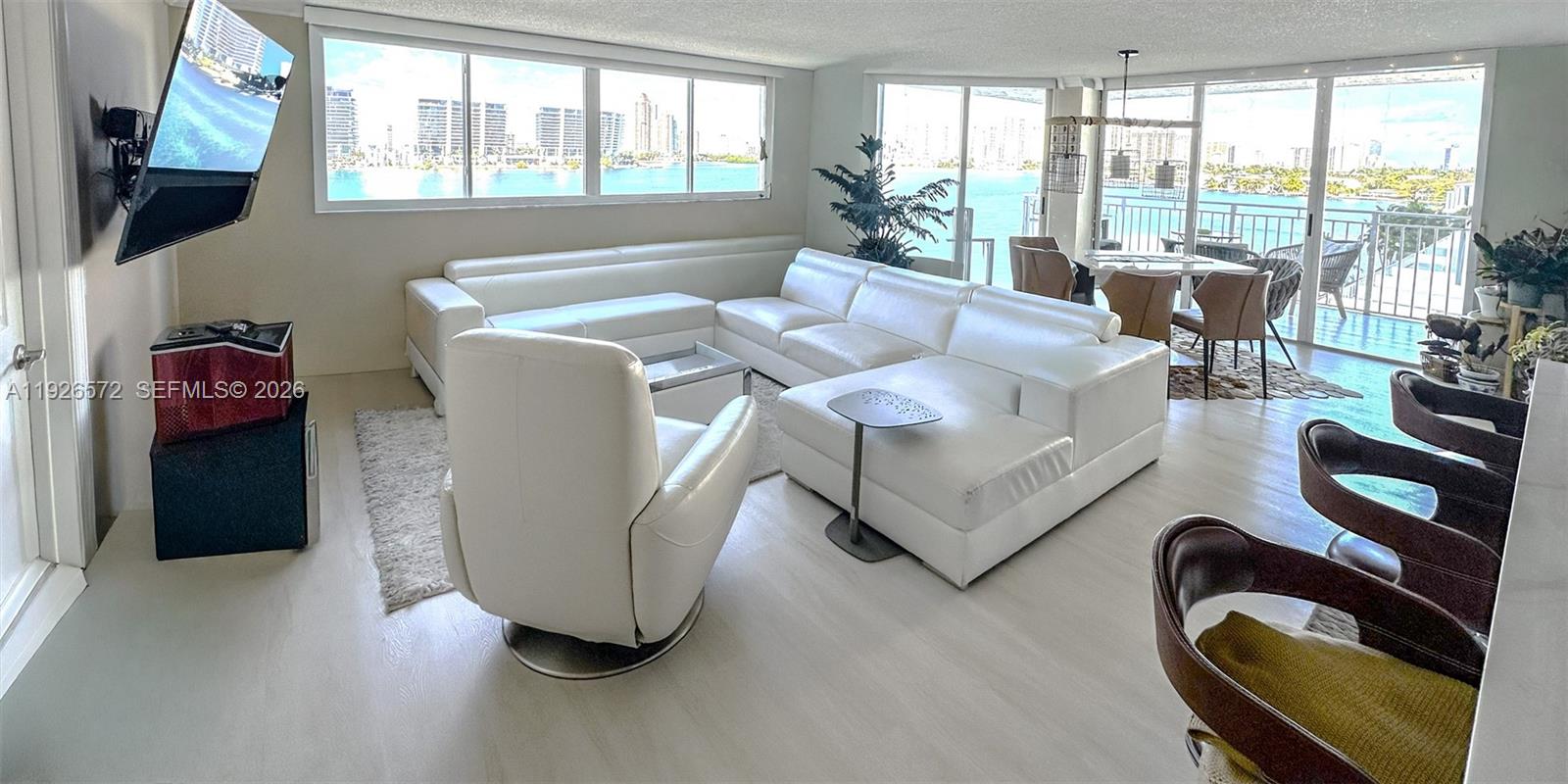 18000 North Bay Road, Unit 603 Sunny Isles Beach, FL 33160 - Photo 5 of 30 a living room with furniture and a floor to ceiling window