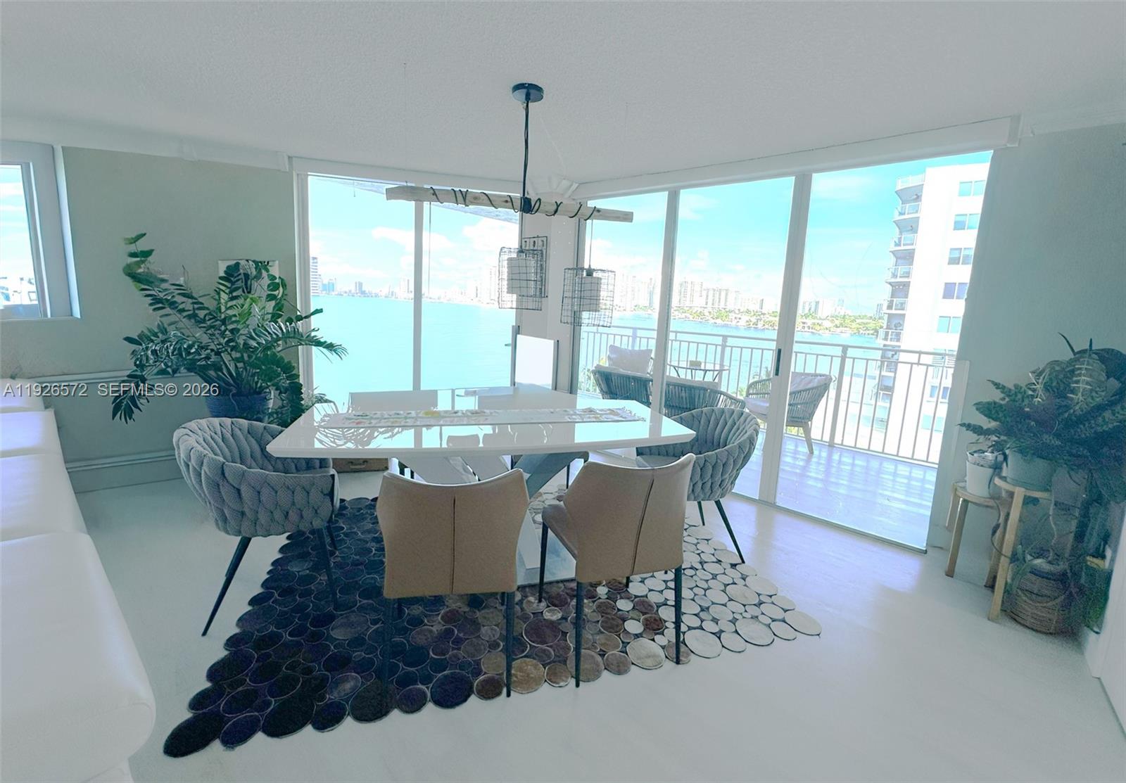 18000 North Bay Road, Unit 603 Sunny Isles Beach, FL 33160 - Photo 7 of 30 a dining room with furniture a chandelier and wooden floor