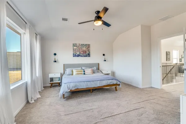a spacious bedroom with a bed and a window