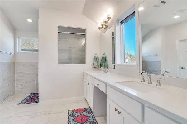 a bathroom with a double vanity sink mirror and shower