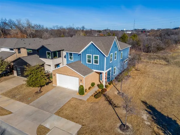 an aerial view of a house with a yard and mountain view in back