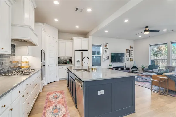 a open kitchen with stainless steel appliances kitchen island granite countertop a sink and cabinets