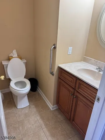 a bathroom with a granite countertop toilet and a sink