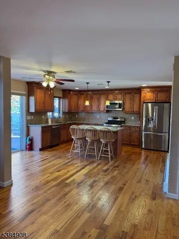 a kitchen with stainless steel appliances a dining table chairs and granite counter tops