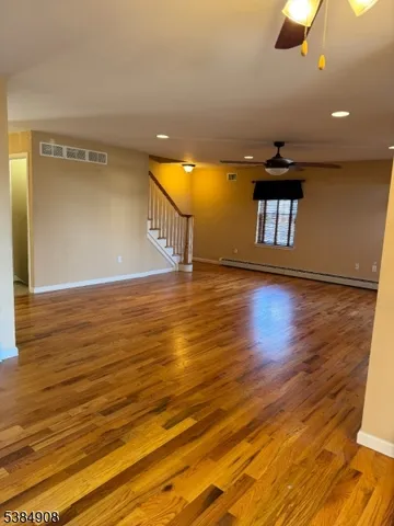 a view of empty room with wooden floor