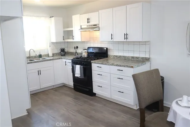 a kitchen with granite countertop white cabinets and white appliances