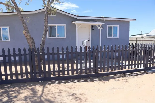a view of a house with wooden fence