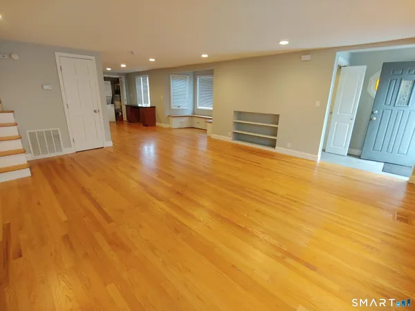 a view of empty room with wooden floor