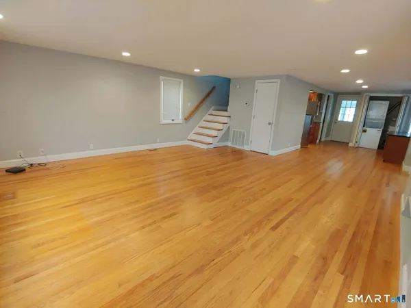 a view of an empty room with wooden floor