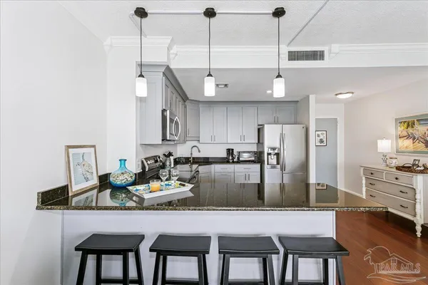 a kitchen with stainless steel appliances granite countertop a kitchen island a stove a table and chairs