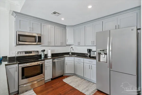 a kitchen with stainless steel appliances a stove a sink and a microwave