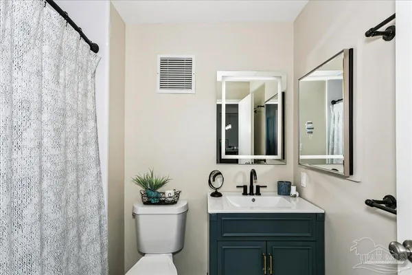 a bathroom with a sink a toilet and a mirror