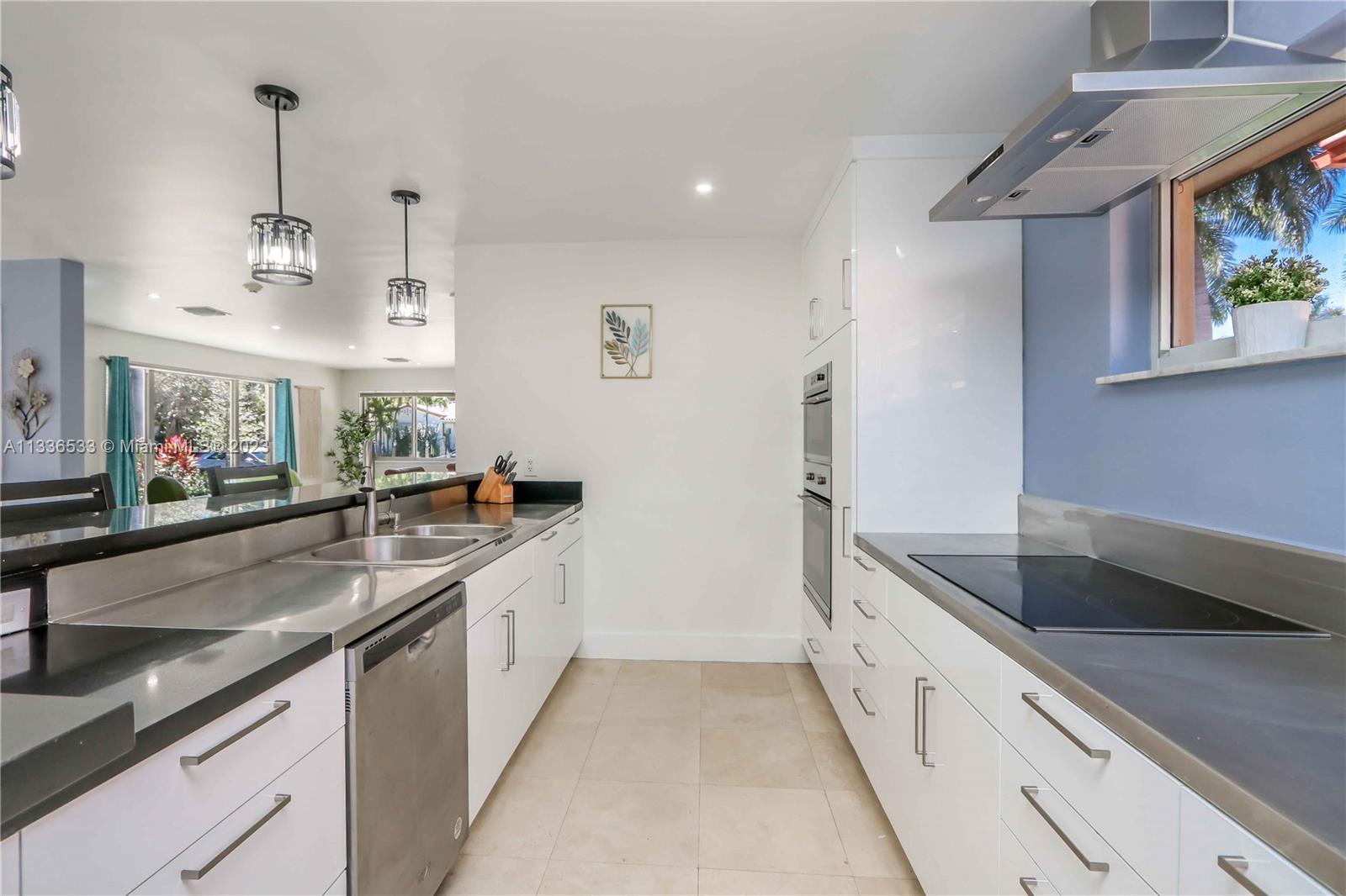 735 Tyler Street Hollywood, FL 33019 - Photo 21 of 35 a large kitchen with stainless steel appliances granite countertop a sink and dishwasher a oven with wooden cabinets