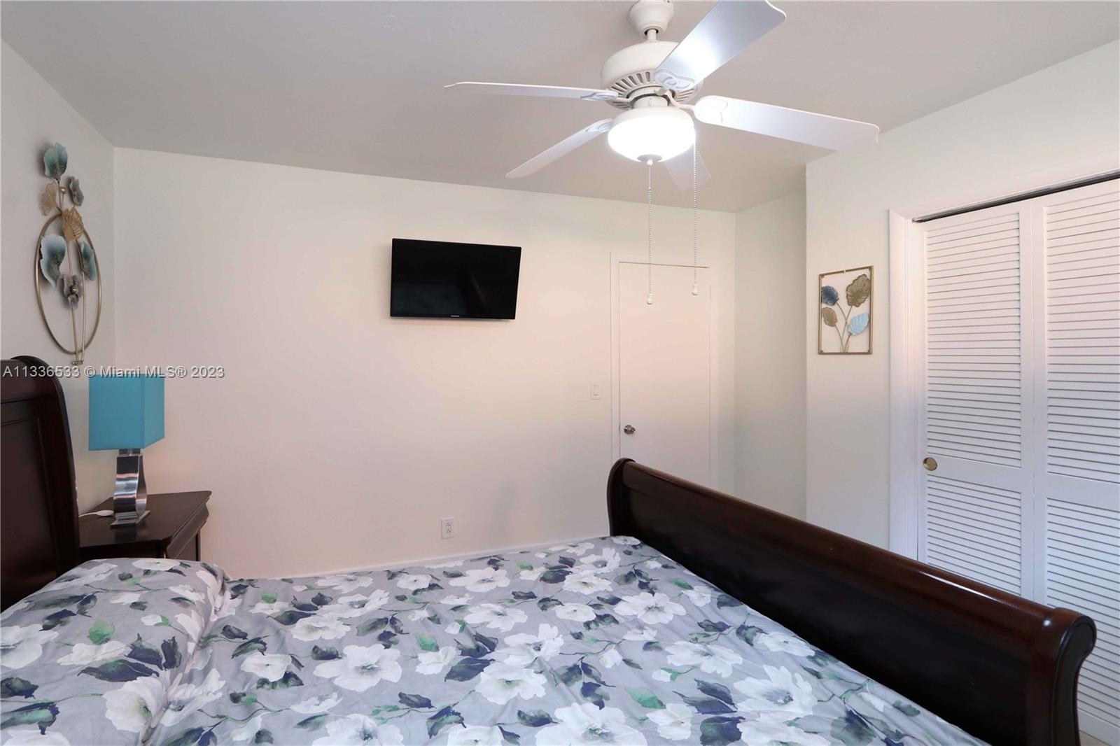 735 Tyler Street Hollywood, FL 33019 - Photo 29 of 35 a bedroom with a bed and a chandelier