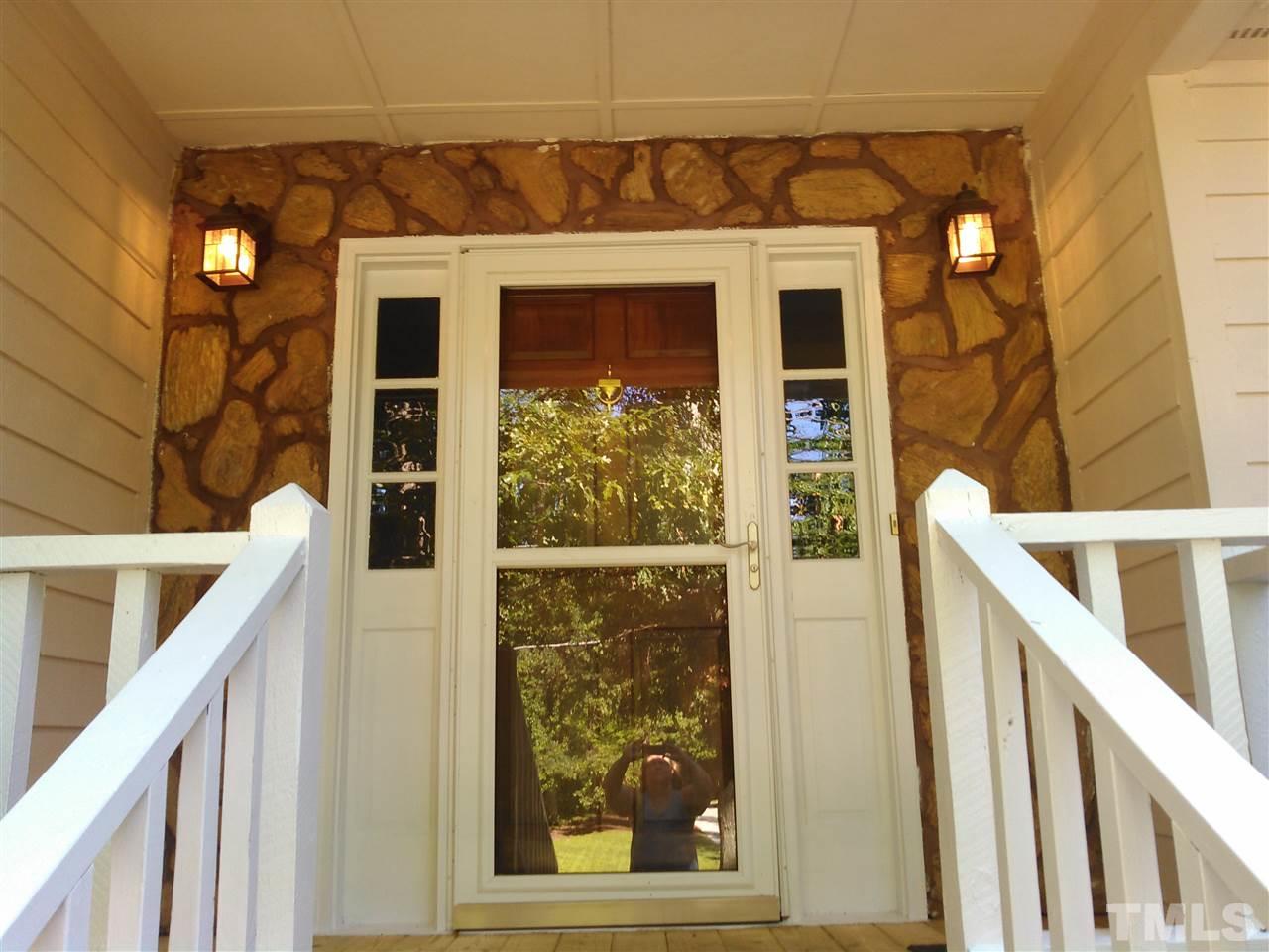 7508 Ray Road Raleigh, NC 27613 - Photo 14 of 18 a view of a house with large windows and wooden fence
